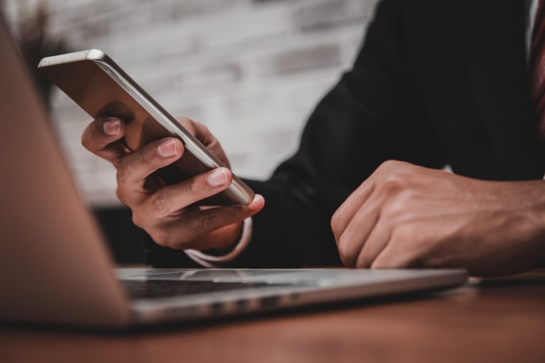 Close up of businessman working in his office with smart phone,d
